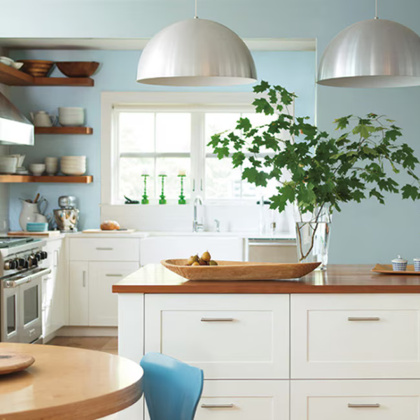 A bright light-blue kitchen with white cabinets painted in Benjamin Moore Color Preview colors