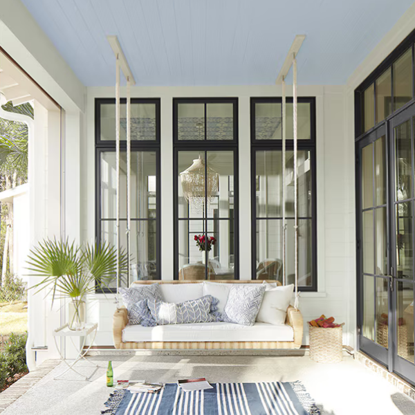 A patio area and porch swing with exterior walls painted in Benjamin Moore Off White Collection paint